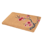 Angled view of thick natural coir doormat with red and pink cherry blossom branch
