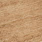 Texture close-up of natural braided jute area rug with ivory border braid