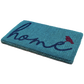 Angled view of thick teal coir doormat with cursive navy 'home' and red bird