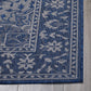 Corner close-up of navy and gray medallion outdoor rug floral border