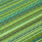 Texture close-up of green striped outdoor rug woven stripes