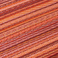 Texture close-up of red and orange striped outdoor rug fine stripes
