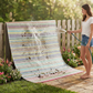 Woman rinsing leaves off candy pastel striped outdoor rug draped over a picket fence