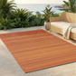 Terracotta Outdoor Rug, lifestyle patio scene with wicker sofa and ocean view