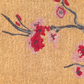 Texture close-up of cherry blossom cluster on natural coir doormat bristles