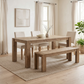 Dune solid acacia bench in Weathered Natural at a wood dining table with cream upholstered chairs in a bright dining room