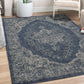 Lifestyle view of blue and ivory medallion outdoor rug in living room by white chair