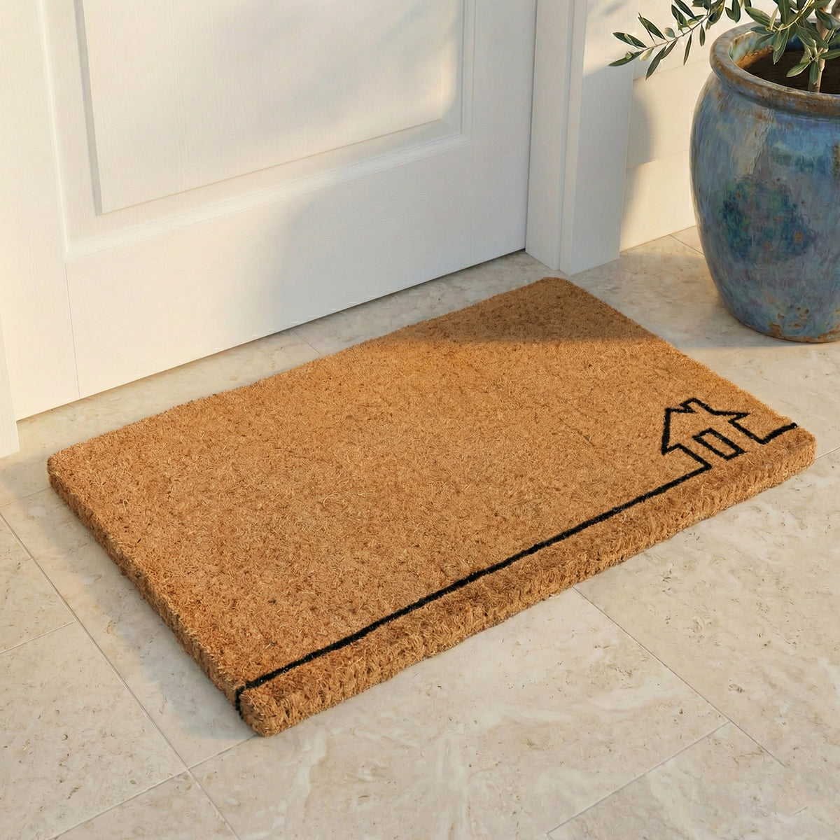 Lifestyle view of thick natural coir doormat with black line-drawn house outline by blue planter