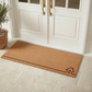 Lifestyle view of wide house outline coir doormat at white double doors