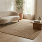 Lifestyle view of natural chunky weave jute area rug in living room