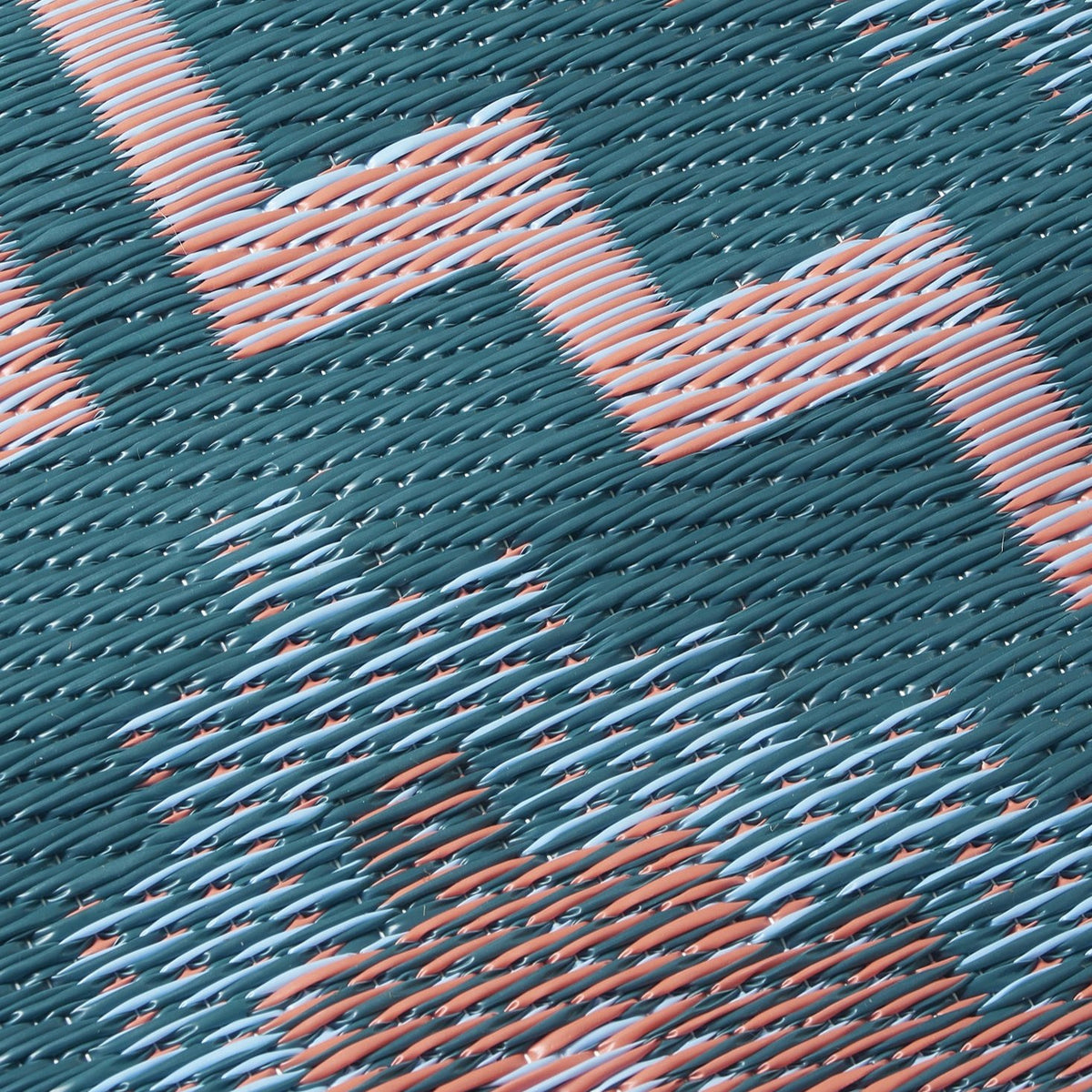 Texture close-up of green diamond outdoor rug showing coral woven strands