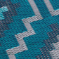 Texture close-up of teal diamond outdoor rug showing woven strands