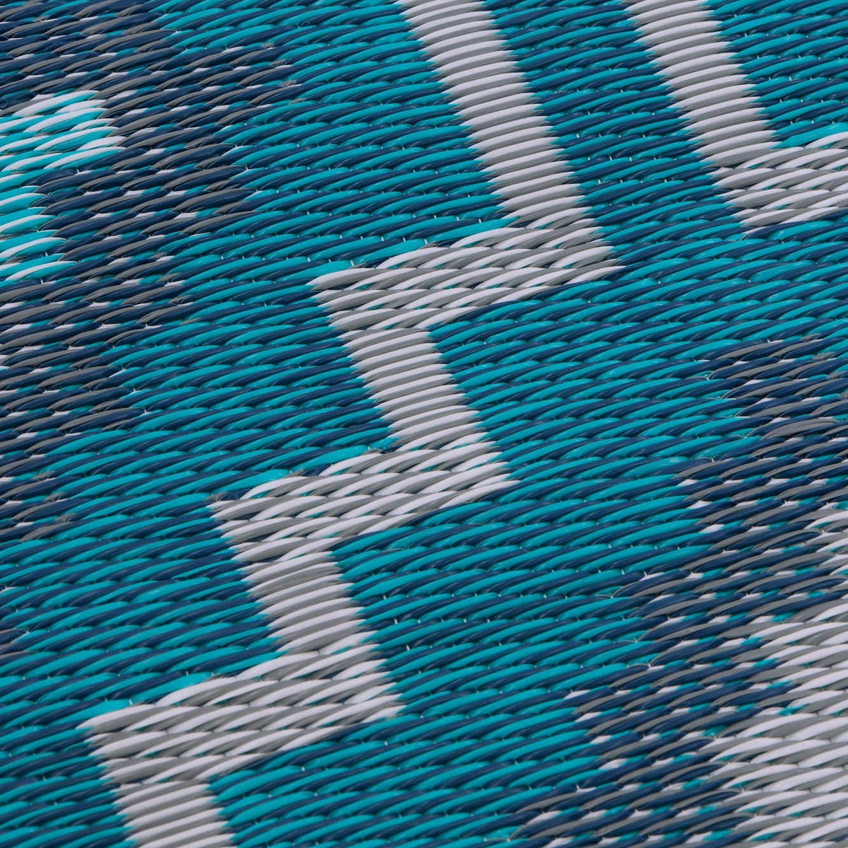 Texture close-up of teal diamond outdoor rug showing woven strands