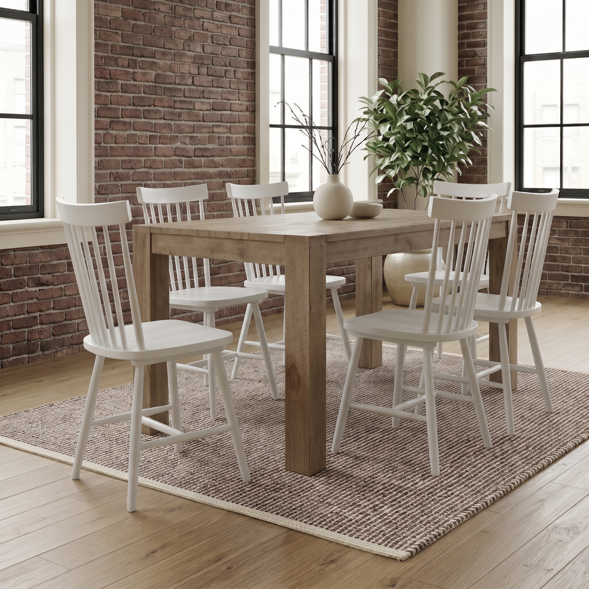 Linnea Windsor dining chairs in Soft White around a wood dining table in a brick loft