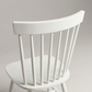 Close up of the curved top rail and spindles of the Linnea Soft White rubberwood dining chair
