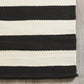 Corner close-up of black and white striped indoor outdoor rug flat weave edge