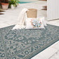 Lifestyle view of ocean blue and ivory medallion outdoor rug on pool deck with succulent pillow
