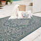 Lifestyle view of ocean blue and ivory medallion outdoor rug with ivory throw by white door