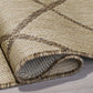 Corner close-up of rolled sand and brown lattice outdoor rug showing flat weave