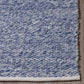 Corner close-up of denim blue indoor outdoor rug bound edge