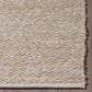 Corner close-up of sand woven indoor outdoor rug with finished edge