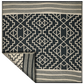 Full view of square black and cream tribal outdoor rug with corner folded back