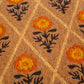 Texture close-up of orange marigold blooms and beige lattice on coir doormat