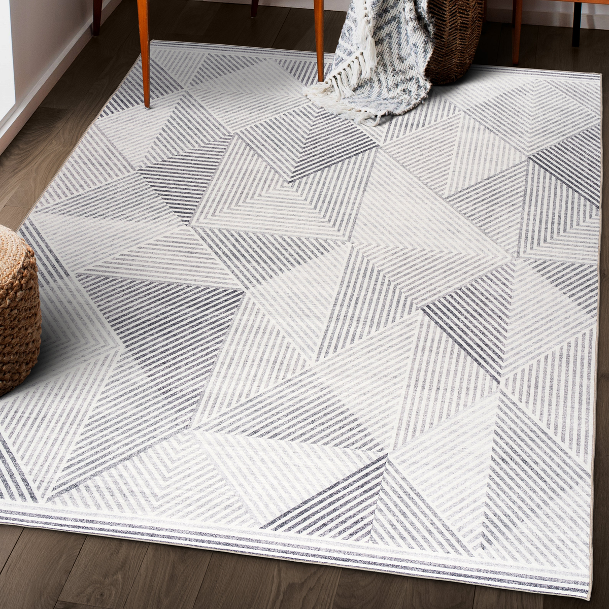 Lifestyle view of gray and ivory geometric machine washable area rug under wooden chair