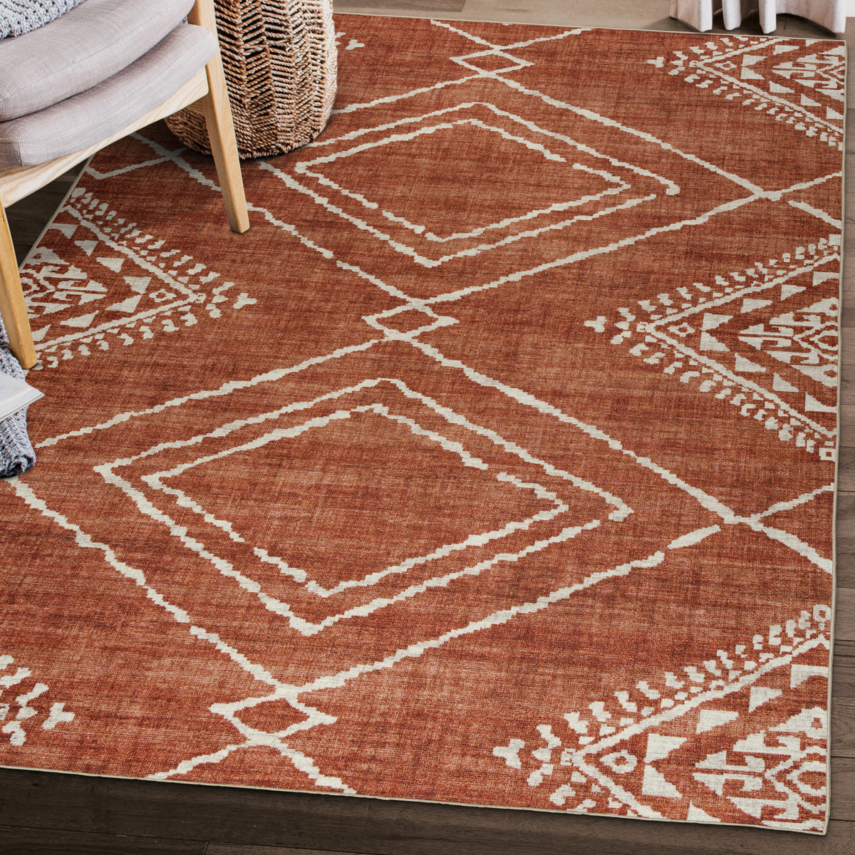 Lifestyle view of orange and ivory diamond machine washable area rug under wooden chair