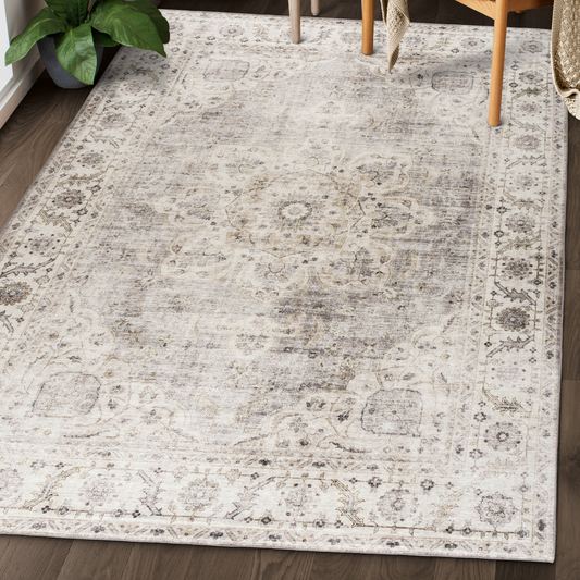 Lifestyle view of beige and ivory medallion machine washable area rug under wooden chair